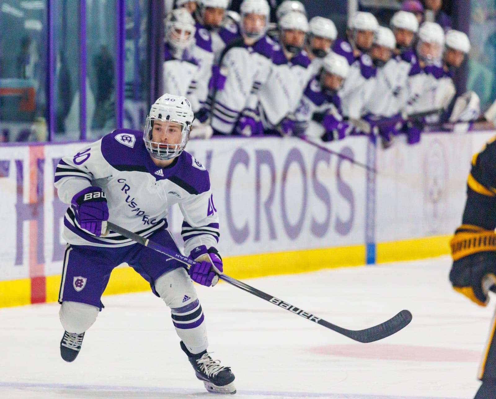 An ice hockey player skates with the puck during a game.